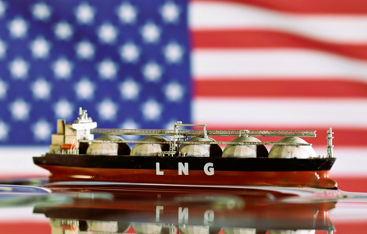 Στη μέση της εικόνας βλέπουμε ένα πλοίο LNG δηλαδή ένα ειδικό «υγραεριοφόρο πλοίο» (LNG tanker) που μεταφέρει υγροποιημένο φυσικό αέριο (Liquefied Natural Gas) σε υγρή μορφή. Από πίσω φαίνεται η σημαία των ΗΠΑ. Πρόκειται για αμερικάνικο LNG. 